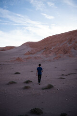A man walking on the desert, on a landscape similar to mars, at sunset, at San Pedro de Atacama