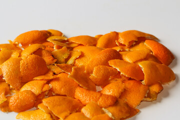 Bright background. Defocus blurred Christmas background from the peels of orange and tangerine on a white background. Many small pieces of dried peel. New Year. Xmas white background. Out of focus