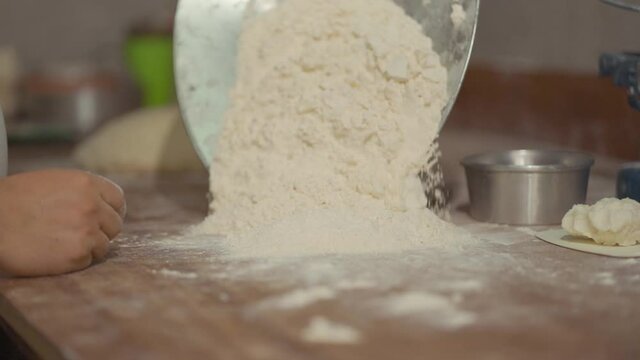 man's hands working with flour
