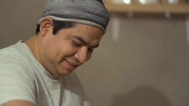 adult man smiling and working in bakery