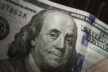 One hundred dollar bill, showing the face of Benjamin Franklin. Extreme macro close up.