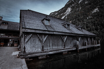 Mountain lake Konigsee in Germany, historic boathouse next to St. Bartholoma church