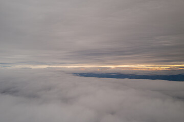 In Between the Clouds With a Sunrise in the Distance