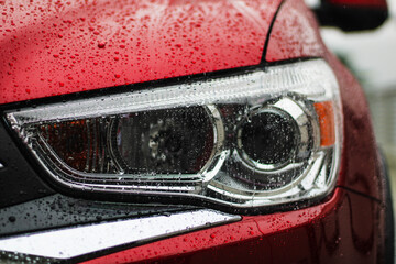 close up of a car headlight in rain