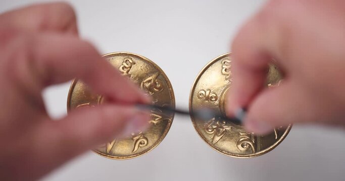 A person holding and using a Tingsha Cymbals or Mane Padme Hum Symbols from Nepal