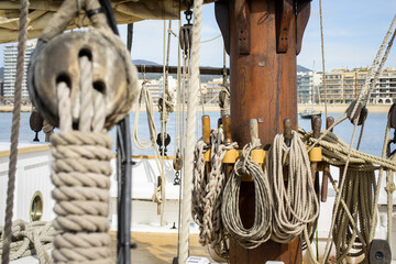 Ropes wrapped around the mast of an old sailing ship.