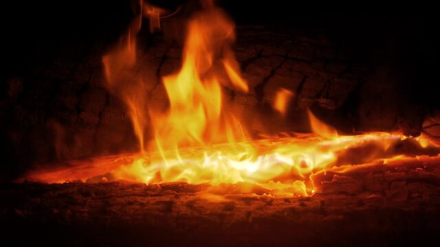 4K Cinematic slow motion macro shot of a fire burning wood in a chimney.