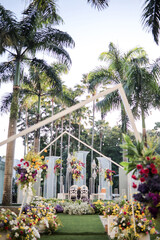 Wedding garden decoration ceremony outdoor. Very beautiful and stylish wedding edge, decorated with various fresh flowers, standing in the garden. Wedding day. Fresh flowers decorations