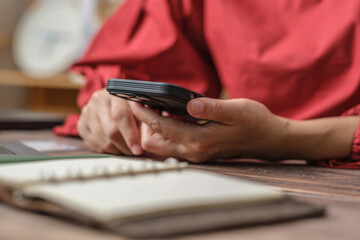 close up woman hand using credit card shopping online on mobile app on wood table at home