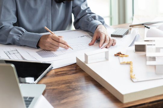 Female architectural designer studying housing designs, Housing designers, home furnishings, working at home, Construction cost estimation, Home model, best search analysis.