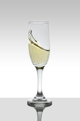 glass with moving white wine and white gradient color background with coffee.
