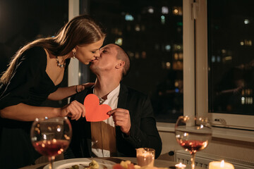 Date at night couple having dinner with candles, family celebrating valentine's day at home, wine in glasses on the table, 14 february woman in love