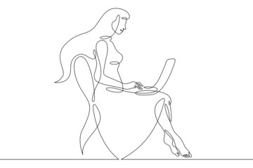 Young woman sits with laptop. Communication and work on the Internet. The girl communicates using a computer.