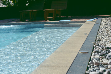 Blue swimming pool with rock flooring stripes summer vacation.
