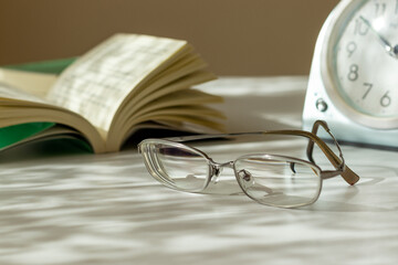 机の上に置かれたメガネと本