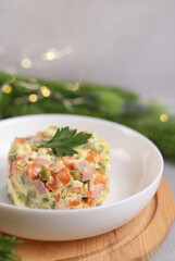 Olivier salad in a white plate close-up. A traditional Russian dish for Christmas and New Year. Selective focus.