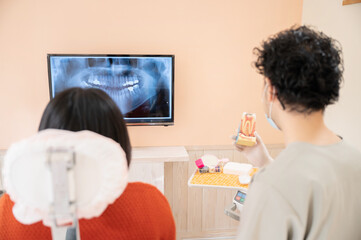 歯科医院で患者さんに笑顔で説明するドクターの様子	