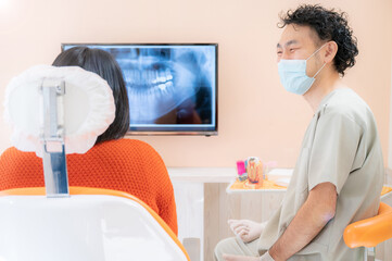 歯科医院で患者さんに笑顔で説明するドクターの様子 - obrazy, fototapety, plakaty