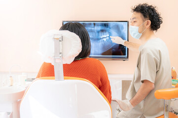 歯科医院で患者さんに説明するドクターの様子 - obrazy, fototapety, plakaty