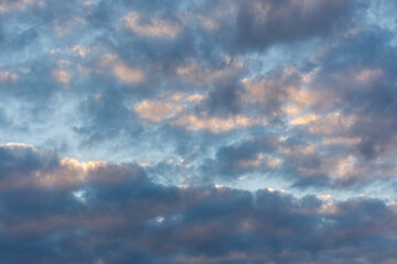 Blue pink clouds texture. Beautiful sunset sky. Natural abstract background. A combination of light blue, pastel pink and purple shades of clouds. Solid cloud cover before the rain. Fluffy dark clouds