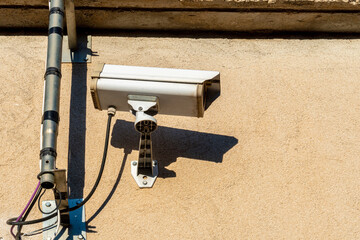 Surveillance camera on a yellow wall.