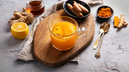 Healthy turmeric golden tea on light gray background.