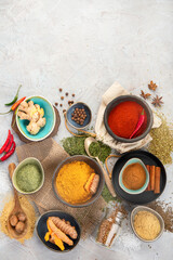 Assortment of Indian spices on gray background.