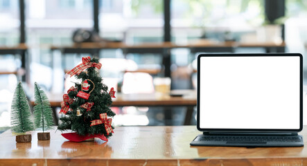 Fototapeta na wymiar portable tablet with christmas tree on wooden table.
