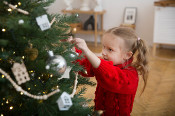 child daughter decorate a Christmas tree together. family meets Christmas together at home. 