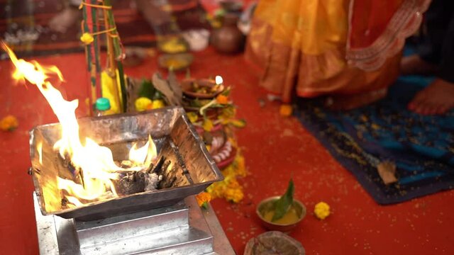 Close up shot of a fire (yagna) with Hindu couple in background during traditional Hindu wedding in India. Slow motion shot.