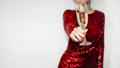 Festive toast. Female congrats. Womans day greeting. Party celebration. Unrecognizable elegant woman in red spangle dress cheering glass of champagne isolated white copy space.