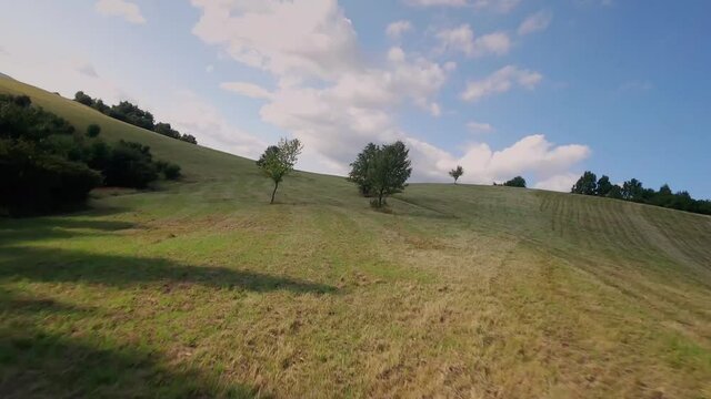 Fpv drone with action camera flying very close to the ground below trees and revealing a beautiful lake at the end. Cinematic footage of nature of National Park Poloniny. Hill called Gazdoran.
