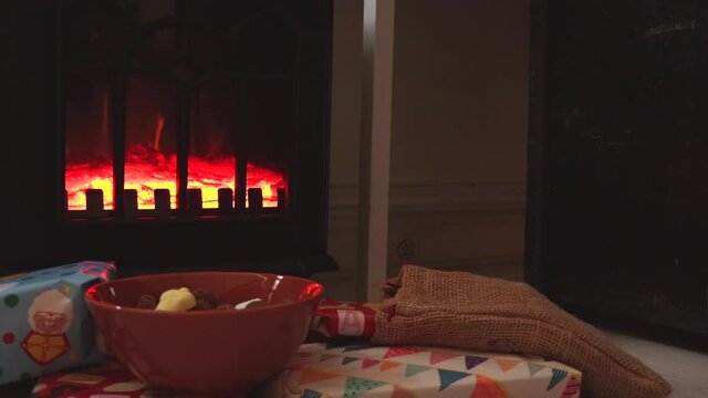Sinterklaas holiday candy and colorful wrapped gifts in front of a fireplace