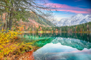 Fairytale view of Fusine lake with Mangart peak on background.