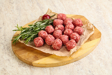 Raw uncooked beef meatballs served rosemary