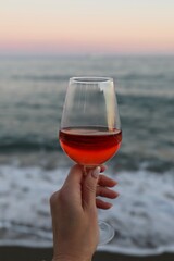 glass of red wine in hand on the beach