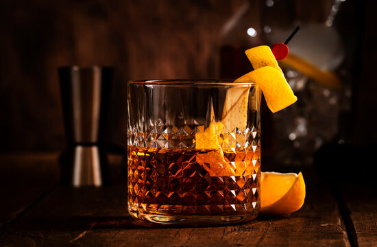 Sazerac, classic alcoholic cocktail with cognac, bourbon, absinthe, bitters, sugar and lemon zest. Old wooden background with copy space