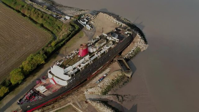 Aerial View Of TSS Duke Of Lancaster, Former Railway Steamer Passenger Ship Beached Near Mostyn Docks In North Wales. drone approach orbit