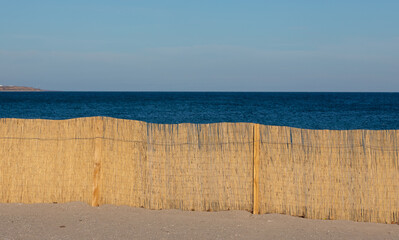 a dry reed fence on the beach