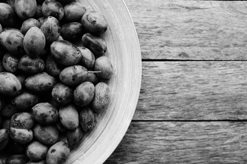 Plate ripe plums in light from window.