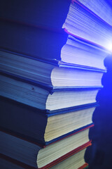 Stack of battered old books.Retro library and books.In a dark room with blue lighting.