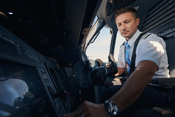 Second pilot pressing switch from his seat in cockpit © Viacheslav Yakobchuk
