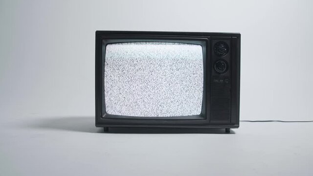 Retro television showing static on a white cyc wall