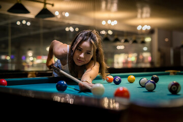 pretty caucasian woman playing snooker at pub