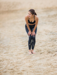 海のビーチでヨガを練習している若い女性ヨガインストラクター