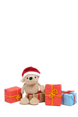 Small teddy bear in a Santa Claus hat sits on boxes with Christmas gifts.On a white background.