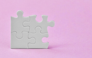 Four puzzle pieces on pink background