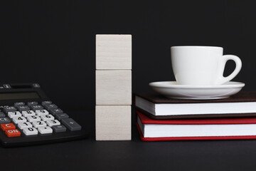 Three blank wooden block cubes on a black background for your text. free space for business concept template and banner. on a black background. red notepad. a cup of coffee