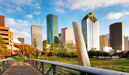 ooden bridge in Buffalo Bayou Park, with a beautiful view of downtown Houston (skyline / skyscrapers) in background on a summer day - Houston, Texas, USA