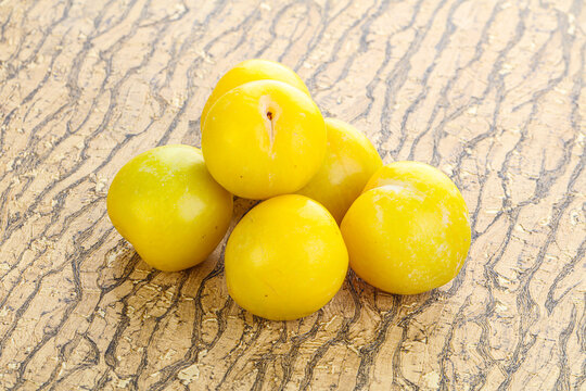 Ripe sweet yellow plum heap over background